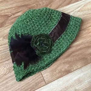 Hand knitted cloche hat with feather and flower
